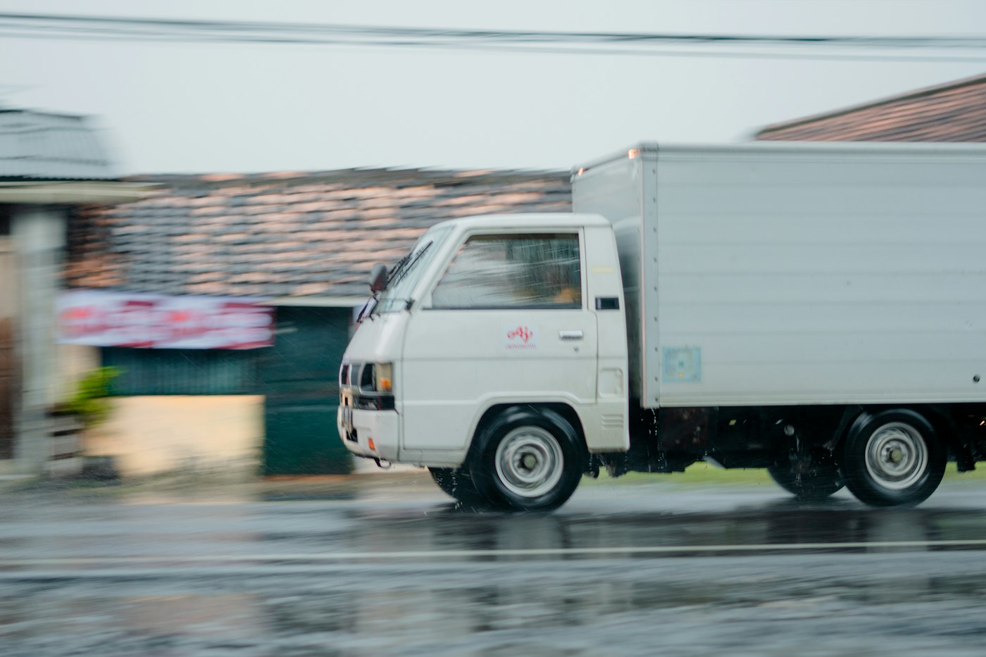 Box truck moving quickly through a town