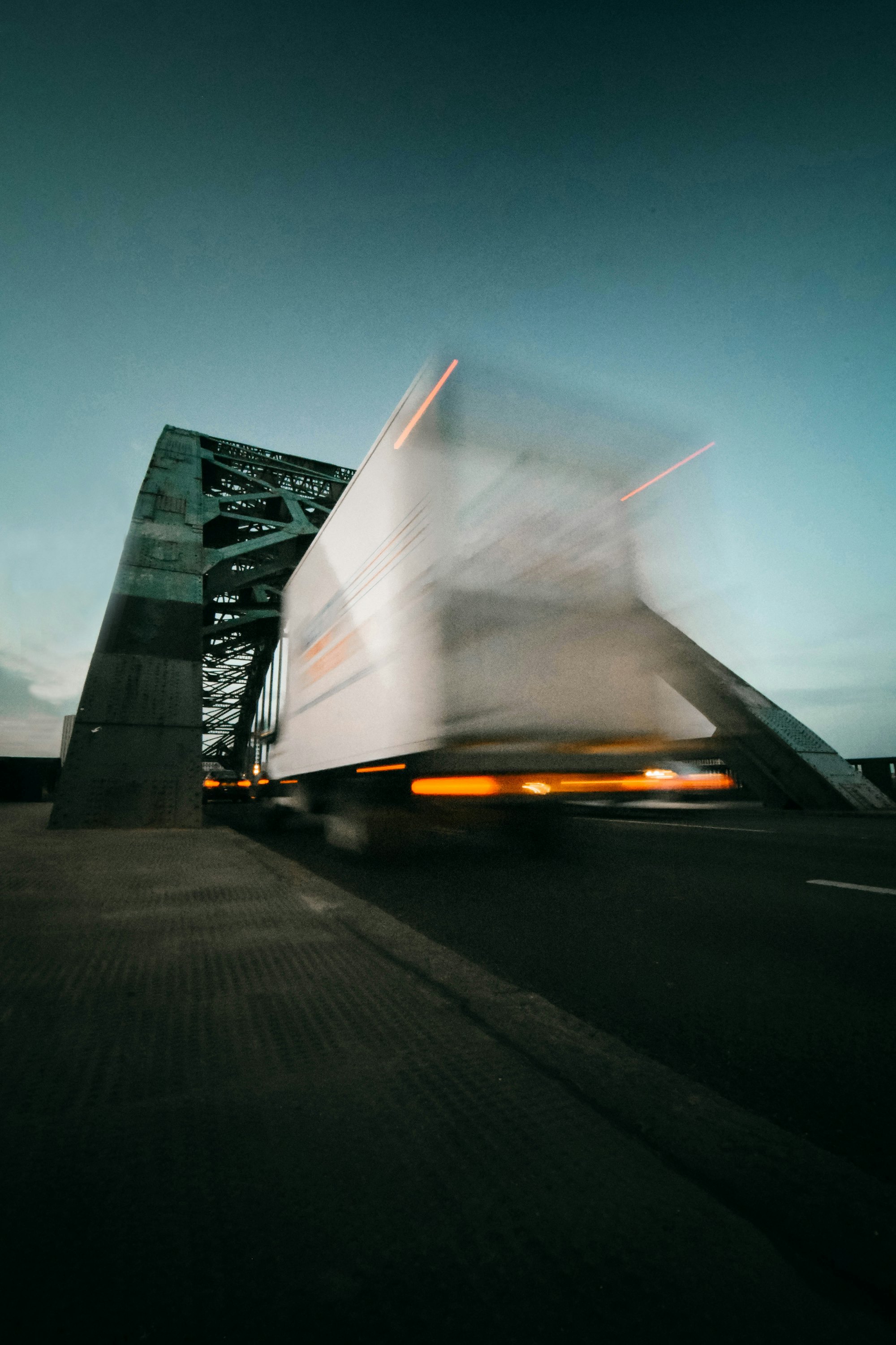 Truck moving fast across a steel bridge